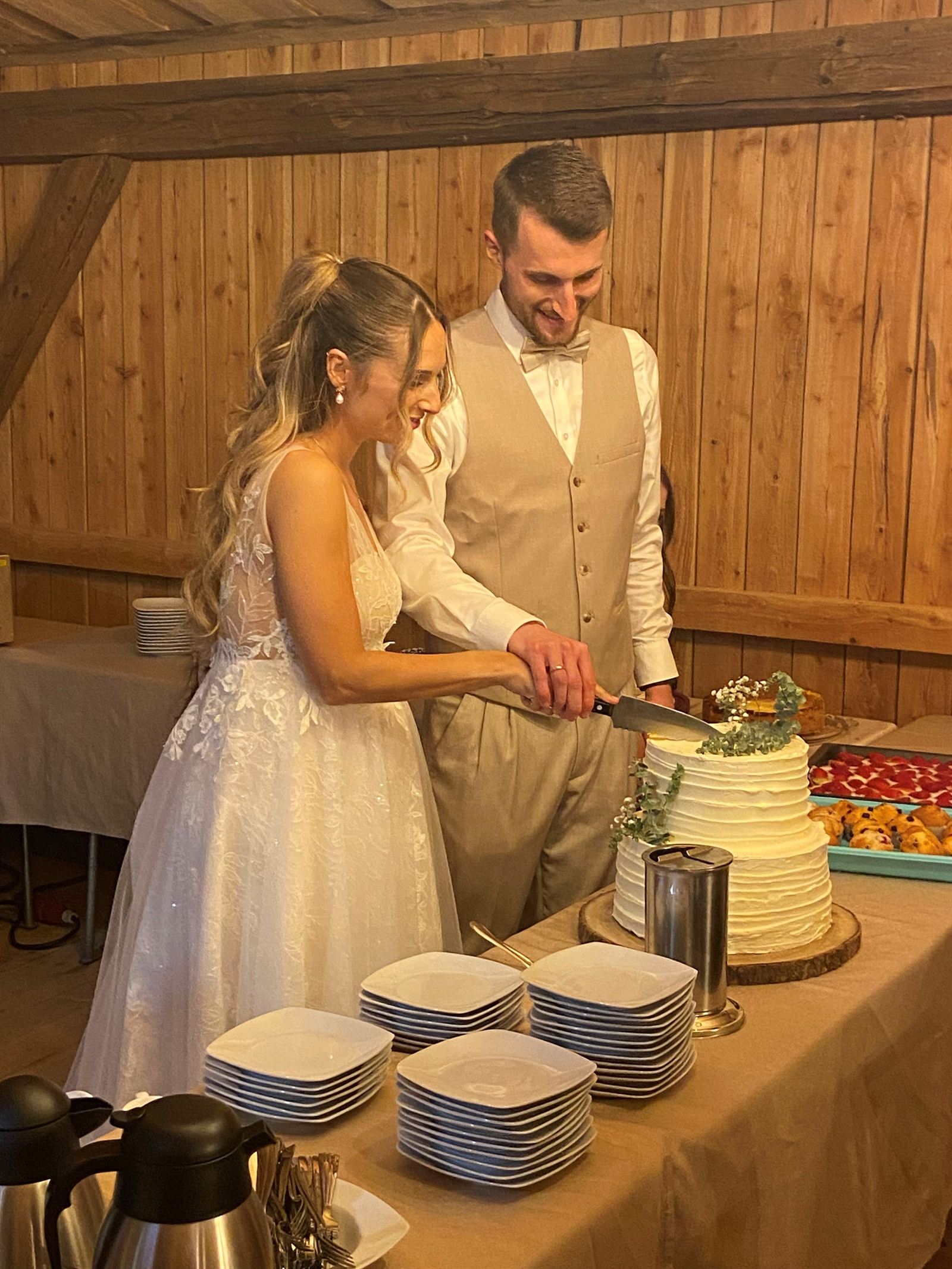 Brautpaar beim Anschneiden der Hochzeitstorte in der Festscheune